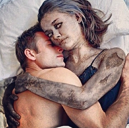 A digitally altered image of a man and woman embracing, both covered in mud or dirt.