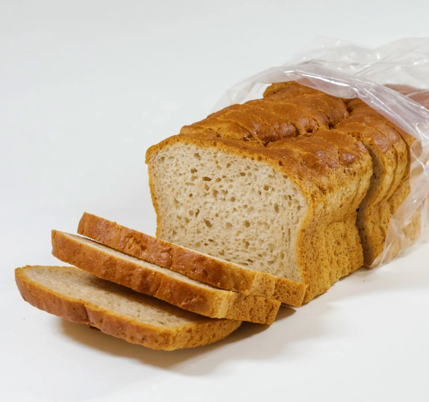 A loaf of sliced bread partially inside a plastic bag.