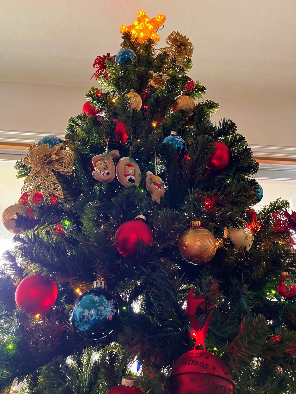 A decorated christmas tree with colorful ornaments and a star topper.