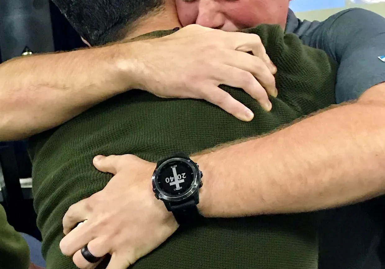 Two men embracing in a heartfelt hug.