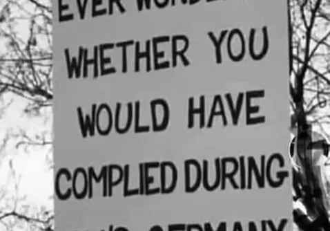 Sign posing a reflective question about compliance relating to 1930s germany.