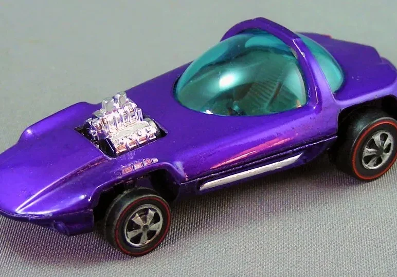 A purple die-cast toy car with a transparent cockpit and an engine detail on the hood.