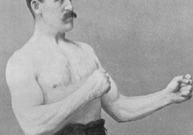 Vintage photograph of a mustachioed man in classic strongman pose.