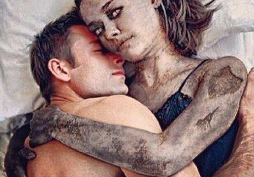 A digitally altered image of a man and woman embracing, both covered in mud or dirt.