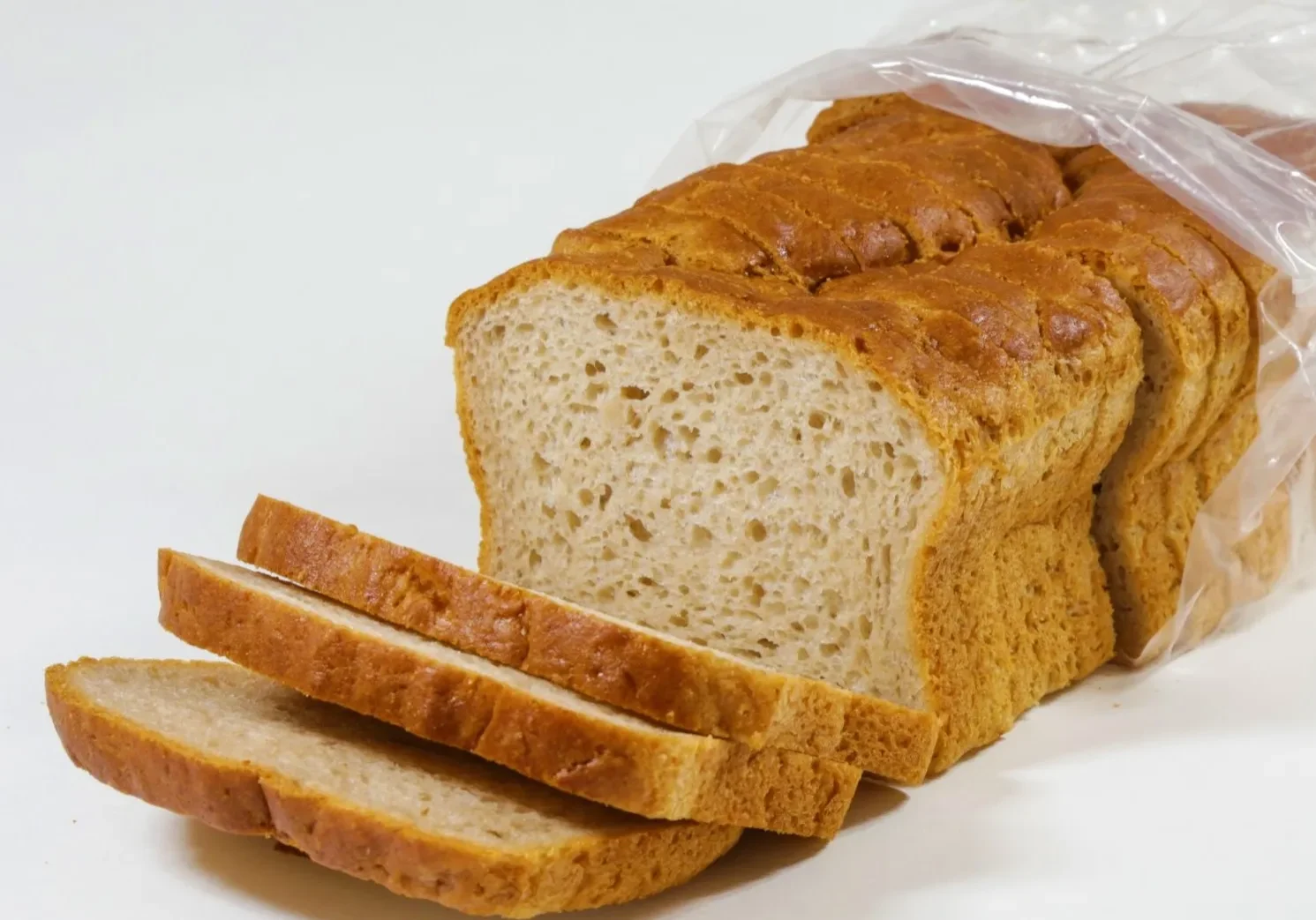 A loaf of sliced bread partially inside a plastic bag.